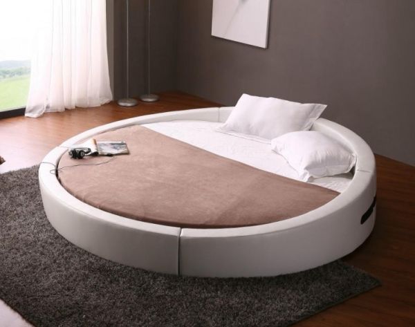 Современная кругла кровать в интерьере помещения