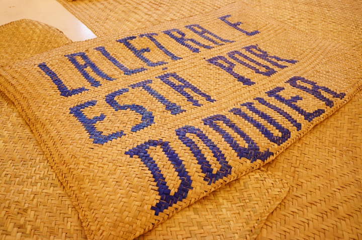 Надпись на плетеном коврике на выставке