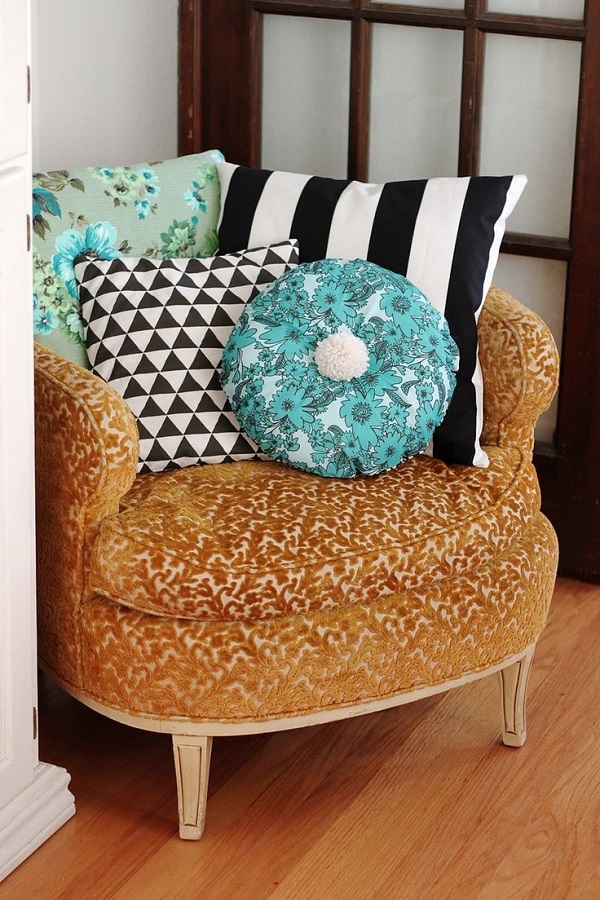 Дизайнерские подушки различных цветов на кресле