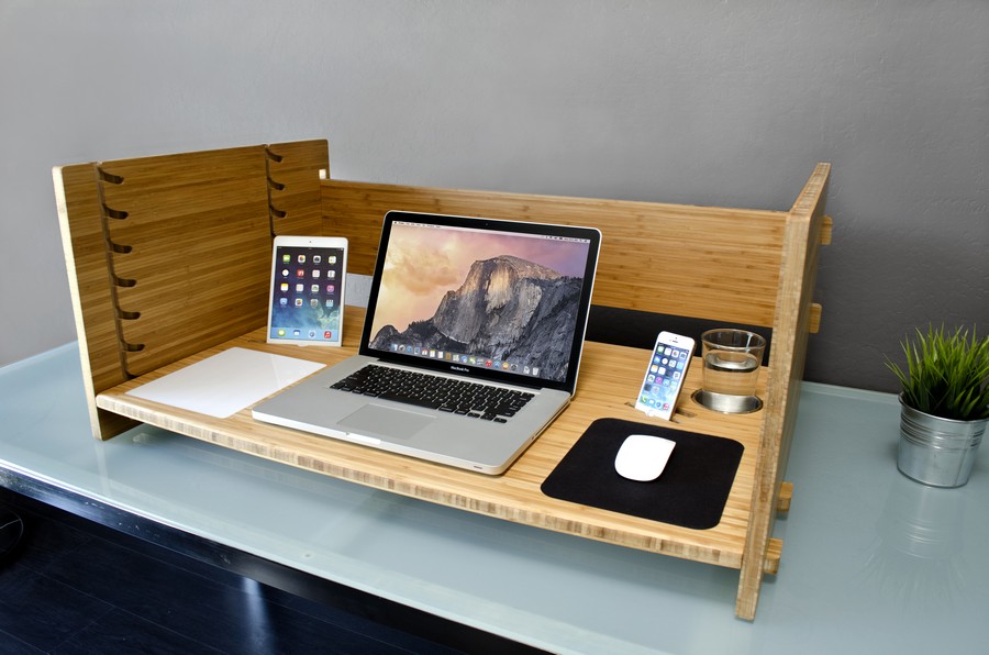 Креативный рабочий стол с установленным на нем ноутбуком, планшетом, телефоном и стаканом