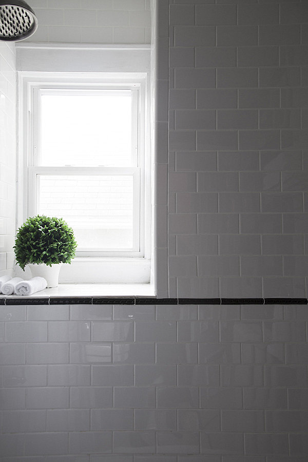 Белый горшок с растения на подоконнике в ванной комнате