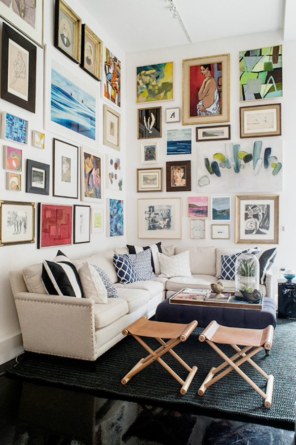 Угловой диван на фоне стены с фотографиями и картинами