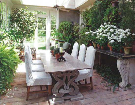 Обеденный стол со стульями в окружении растений
