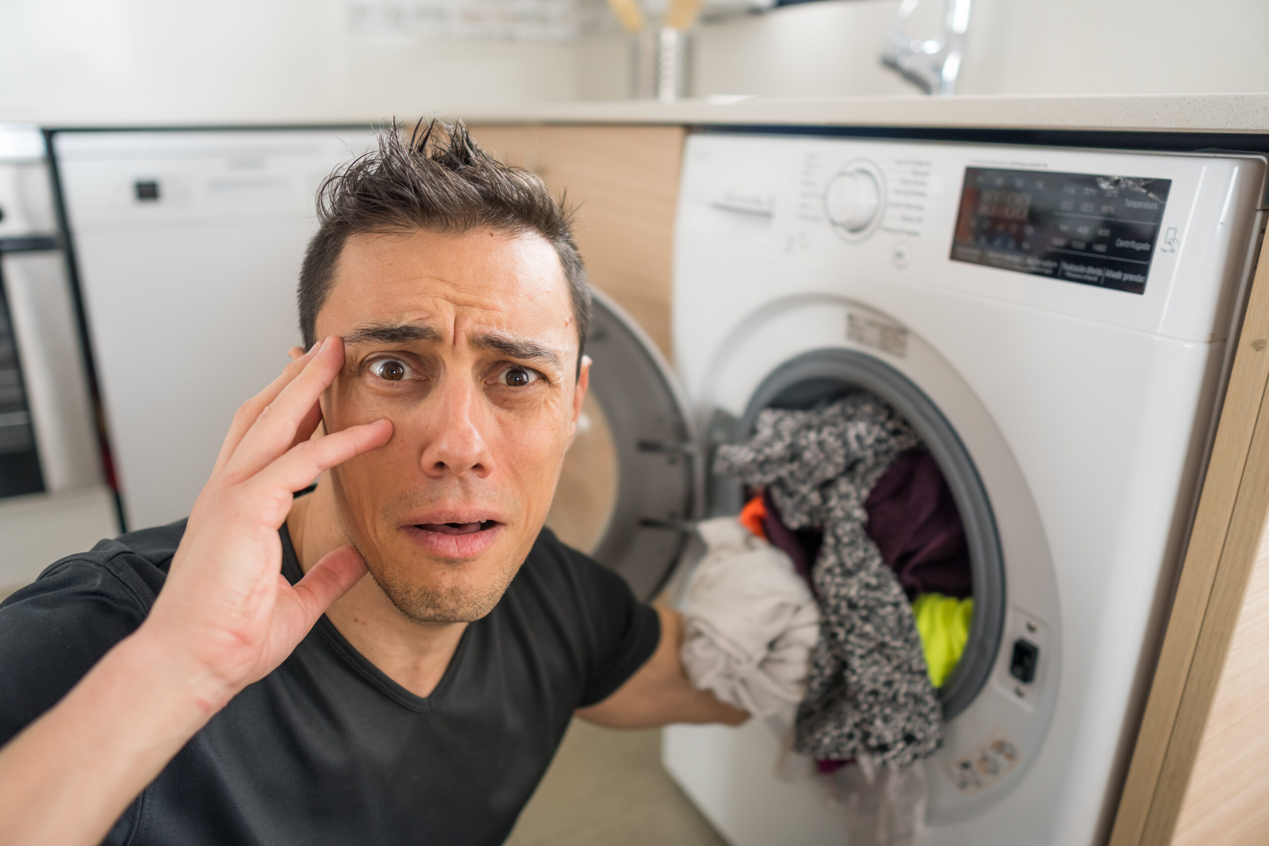 Man putting clothes in the washing machine.