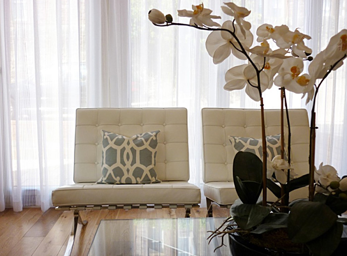 Белые орхидеи в интерьере с креслами barcelona