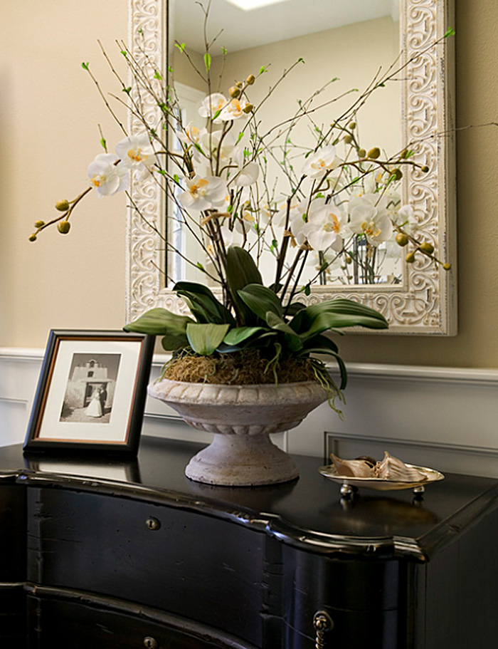 Белые орхидеи в горшке у зеркала