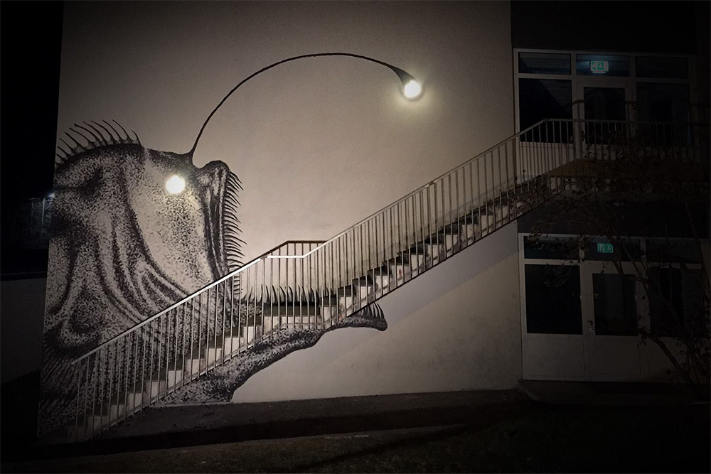 Skurk: фреска с изображением рыбы-удильщика на стене с лестницей и лампочками