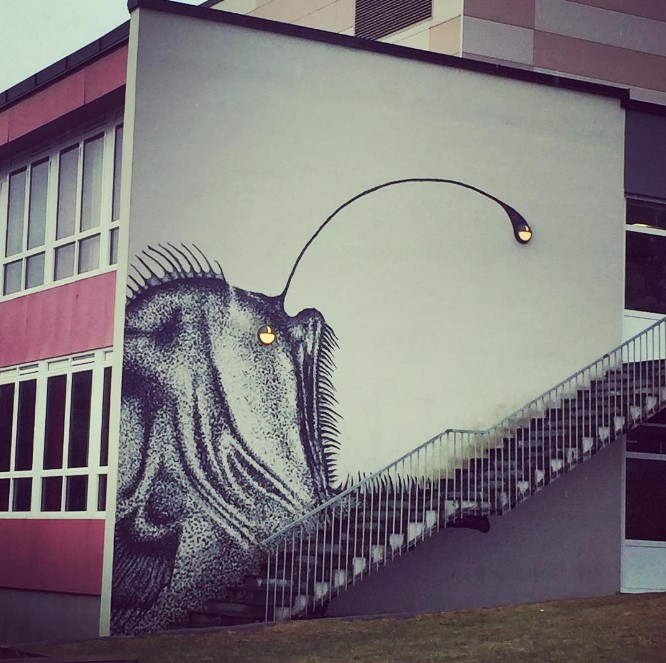 Skurk: фреска с изображением рыбы-удильщика на стене с лестницей и лампочками